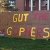 a giant paddleboard with "Gut the Gophers" painted on it
